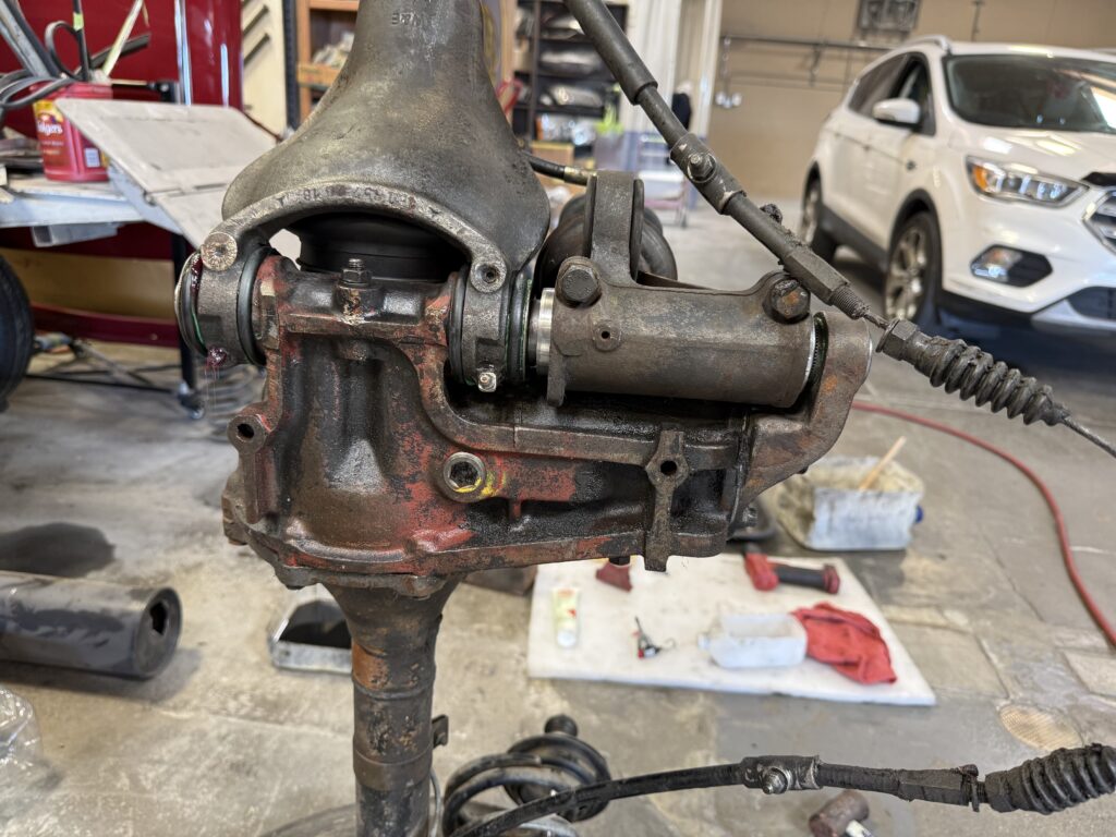 Mercedes SL190 rear differential housing close-up during repair with steering linkage and drivetrain components visible