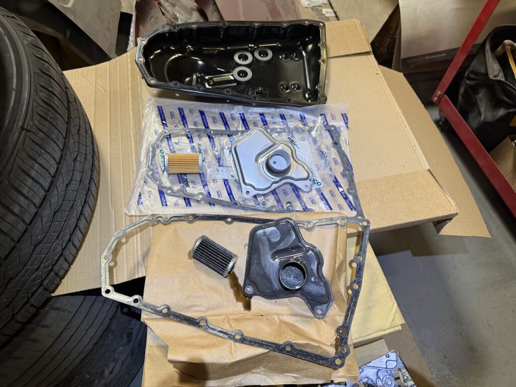 oil pan gasket and filter kit prepared for oil change service with old and new components comparison